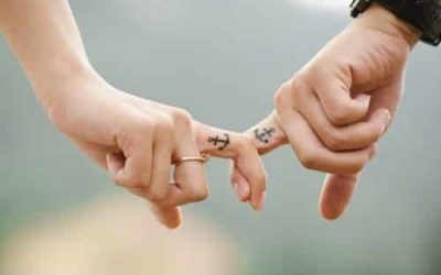 happy-couple-with-matching-tattoos-locking-fingers